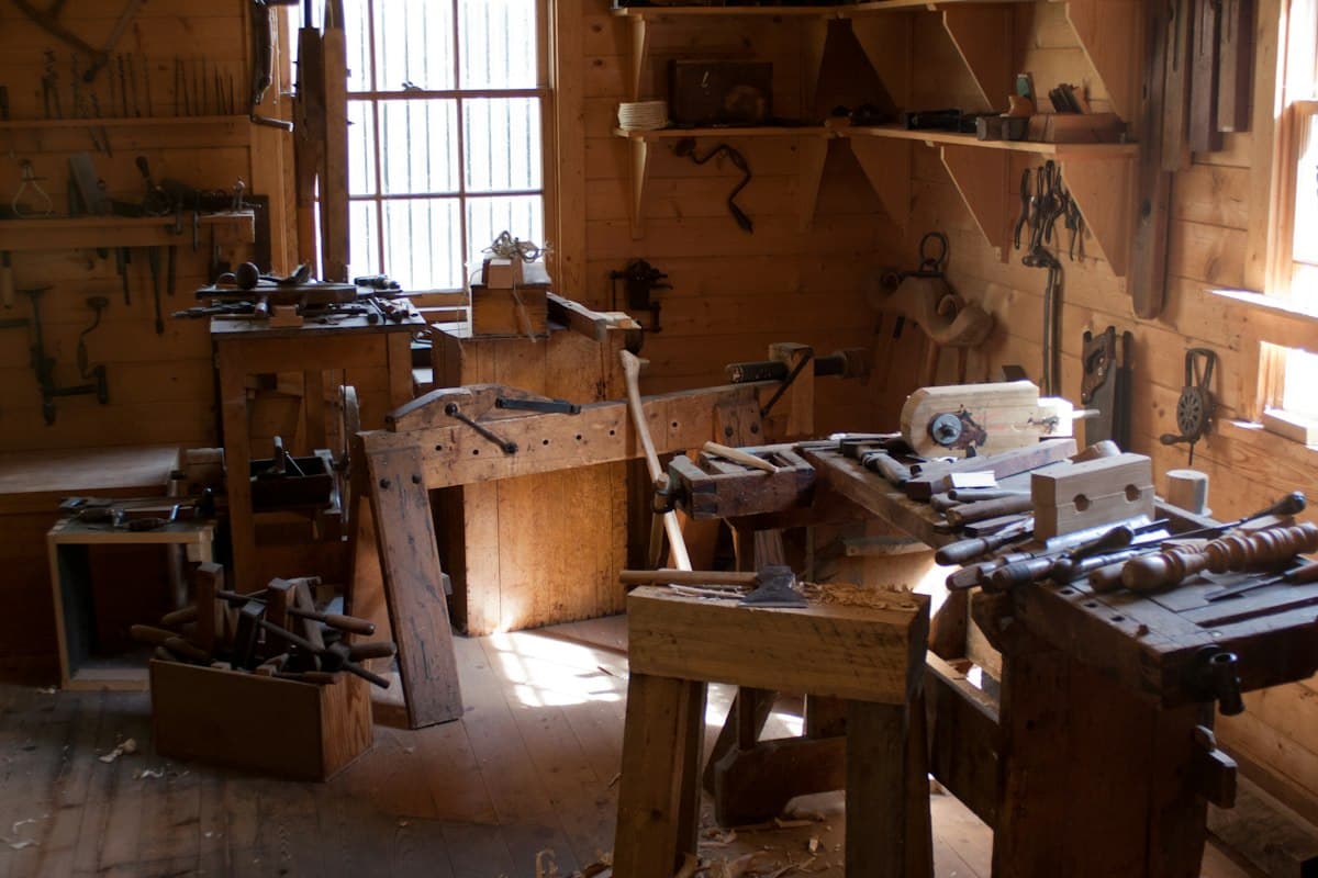 L'atelier : établis, serre-joints et outils à main accrochés au mur